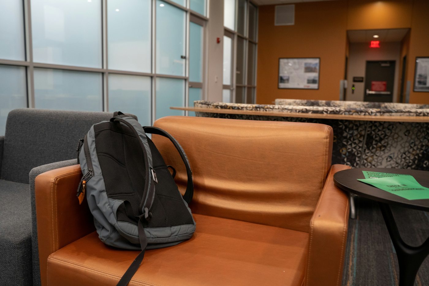A backpack resting on a leather armchair in a quiet waiting area